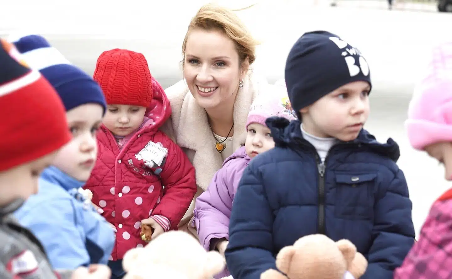 Ukrainske børn, der præsenteres som »forældreløse, der skal placeres hos russiske familier«, ankommer til lufthavn i Moskva. Putins børnekommissær, Maria Lvova-Belova (tv.), tager imod. Foto: Den russiske børnekommissions pressetjeneste.