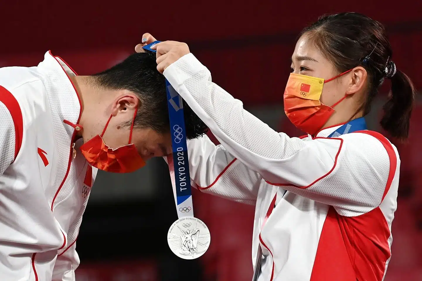 Xu Xin modtager sin sølvmedalje af sin makker Liu Shiwen under medaljeceremonien i Tokyo d. 26 juli, 2021. Foto: Jung Yeon-je, AFP / Scanpix.