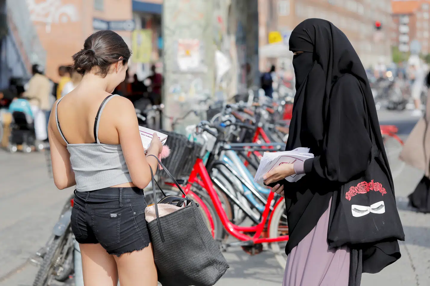 En kvinde fra gruppen Kvinder i Dialog uddeler flyers som led i en kampagne mod tildækningsforbuddet i sommeren 2018. Nye generationer af indvandrere forventer rettigheder og deltagelse i demokratiet, påpeger Aladin El-Mafaalani. Foto: REUTERS/Andrew Kelly