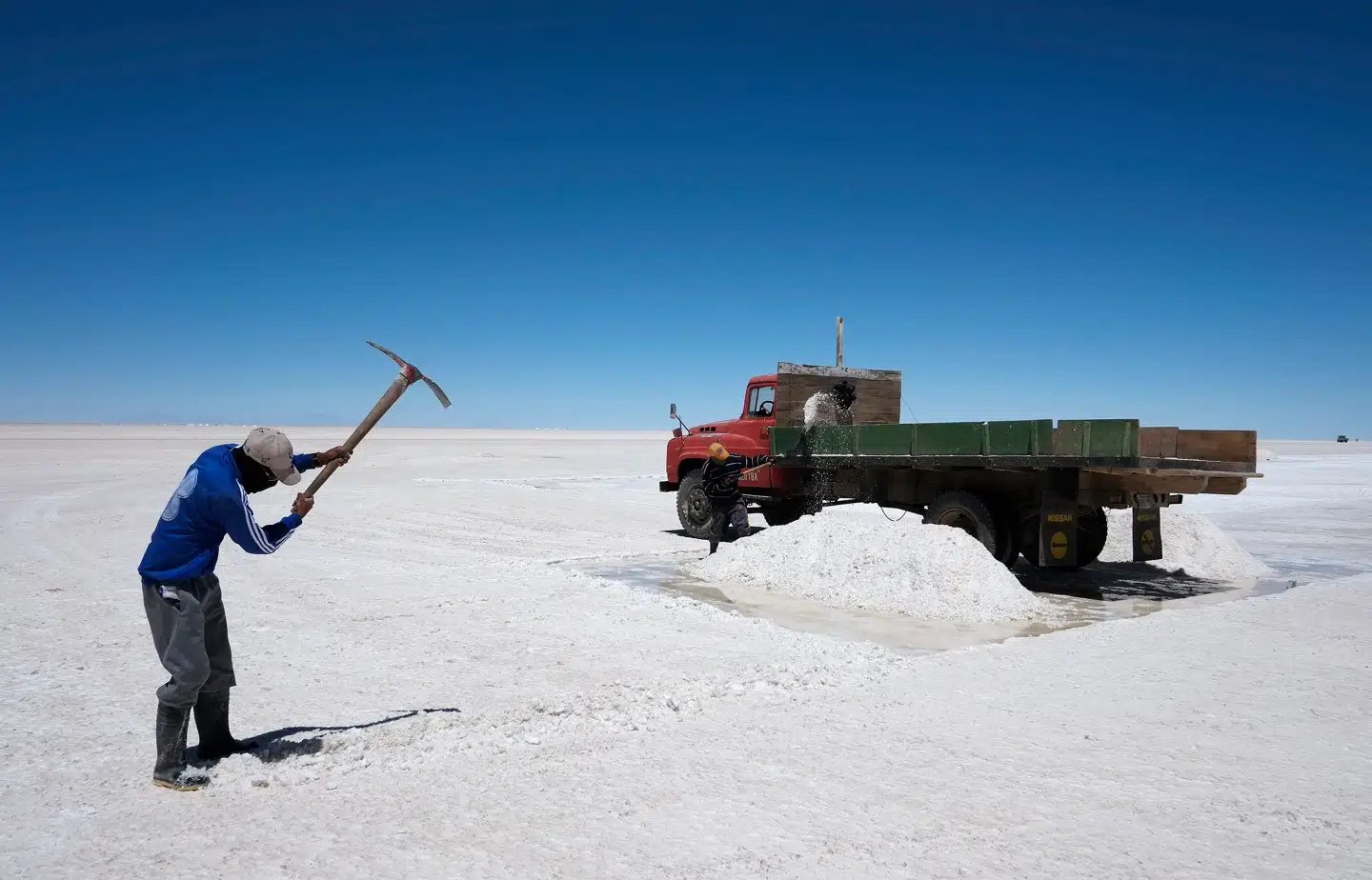 En mand bryder salt på verdens største saltslette Salar de Uyunir i den sydvestlige del af Bolivia. Den rummer kæmpemæssige forekomster af grundstoffet litium, der bruges i batterier. Foto: David Mercado/Scanpix
