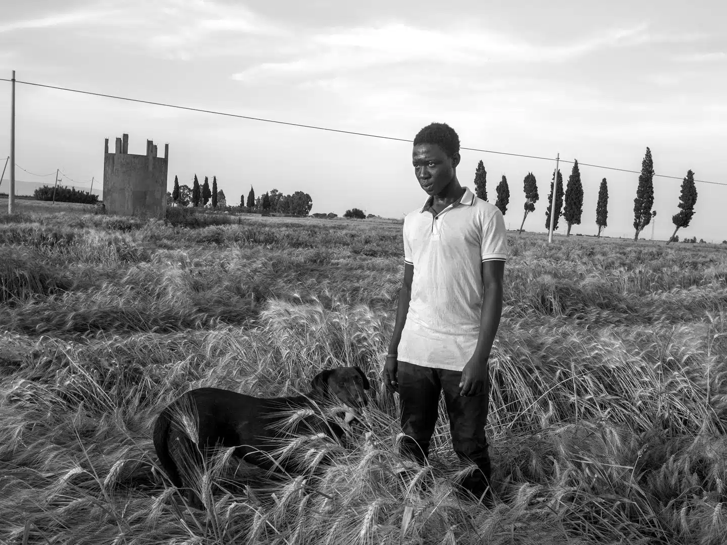 Suman, 15-årig migrant fra Gambia, lufter hunden på den kæmpestore Il Tavoliere-slette i Puglia, uden for den illegale indvandrerghetto La Pista. FOTO: ENRI CANAJ, MAGNUM