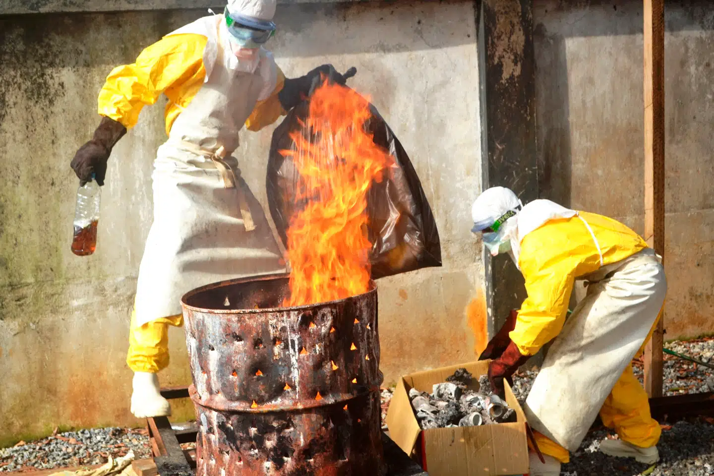 Sundhedsarbejdere brænder brugt beskyttelsesudstyr i den vestafrikanske republik Guinea den 13. september 2014. Foto: Cellou Binani/AFP, Scanpix
