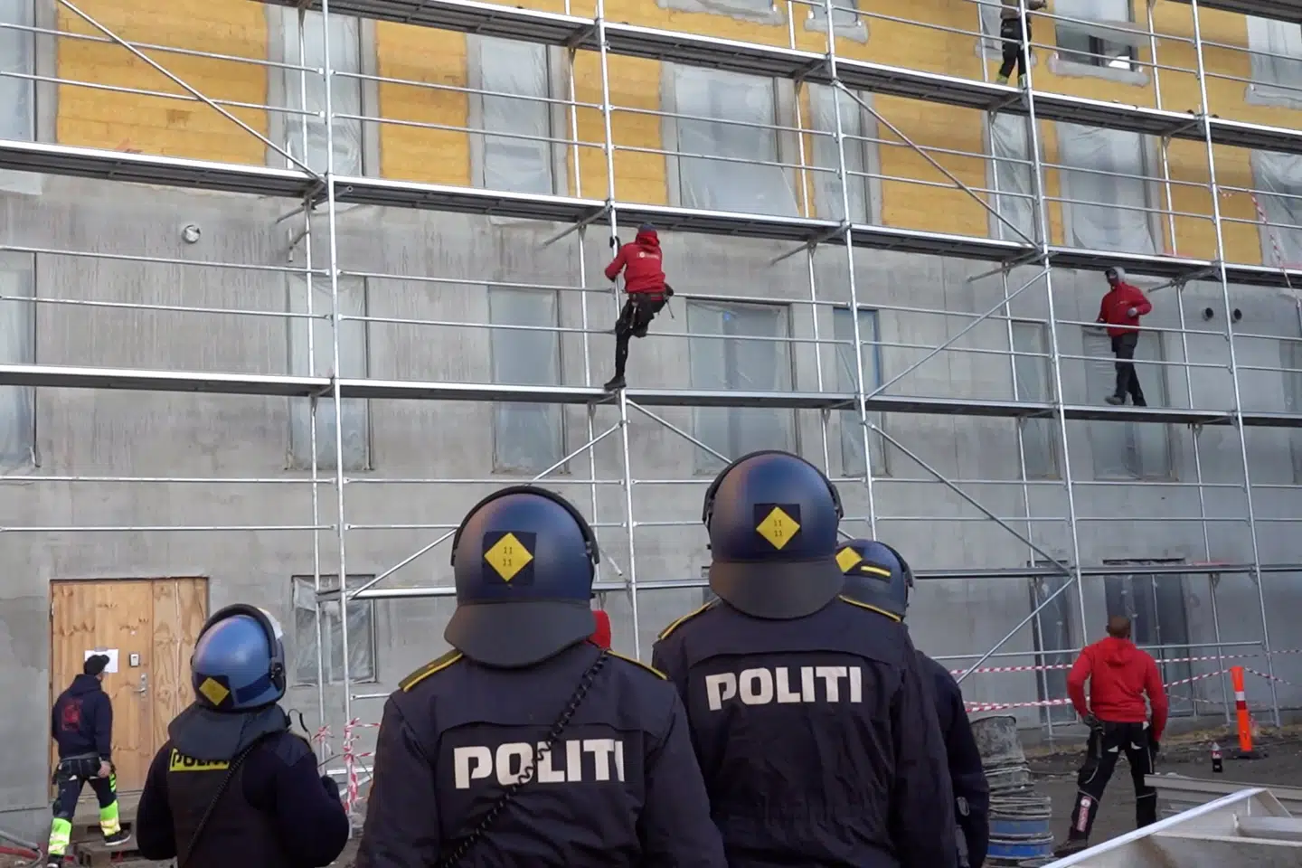 Politiet ser passivt til, mens gerningsmænd gør klar til at vælte et stillads på Nørrebro. Kort efter træder betjentene til side, og stilladset væltes. 2. december 2019. Foto: Linda Kastrup