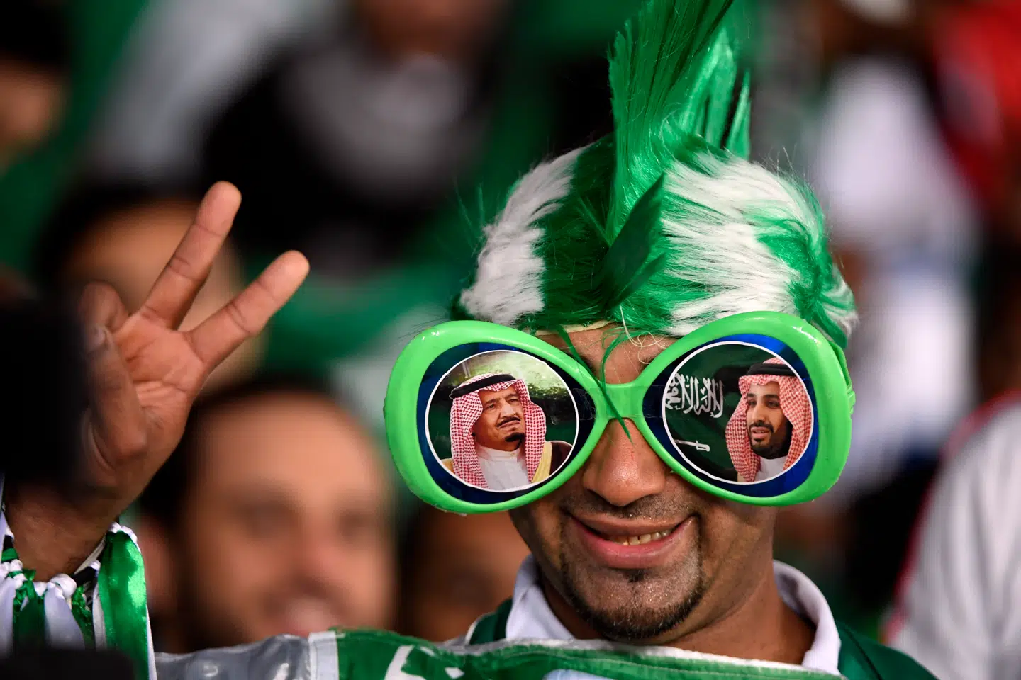 En saudisk fodboldfan bærer solbriller med portrætter af kong Salman og kronprins Mohammad bin Salman. I Saudi-Arabien har man ingen problemer med at blande sport og politik.
FOTO: KHALED DESOUKI/AFP/RITZAU SCANPIX