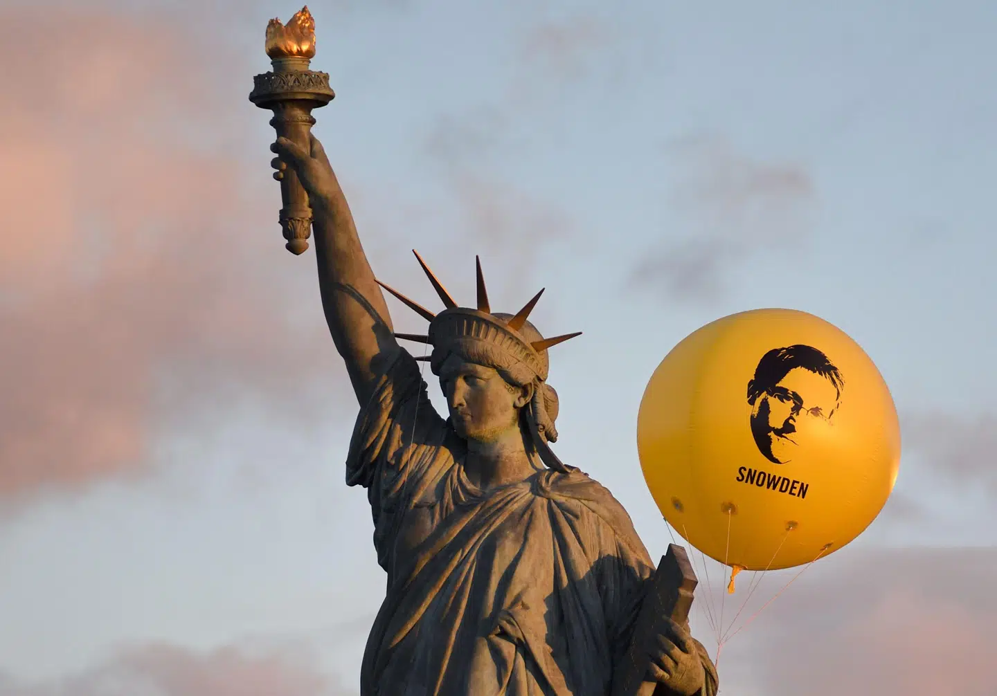 Edward Snowden i hænderne på Frihedsgudinden – vel at mærke den parisiske replika af den franske skulptør Auguste Bartholdis berømte værk (1834-1904). Foto: Eric Feferberg/Ritzau Scanpix