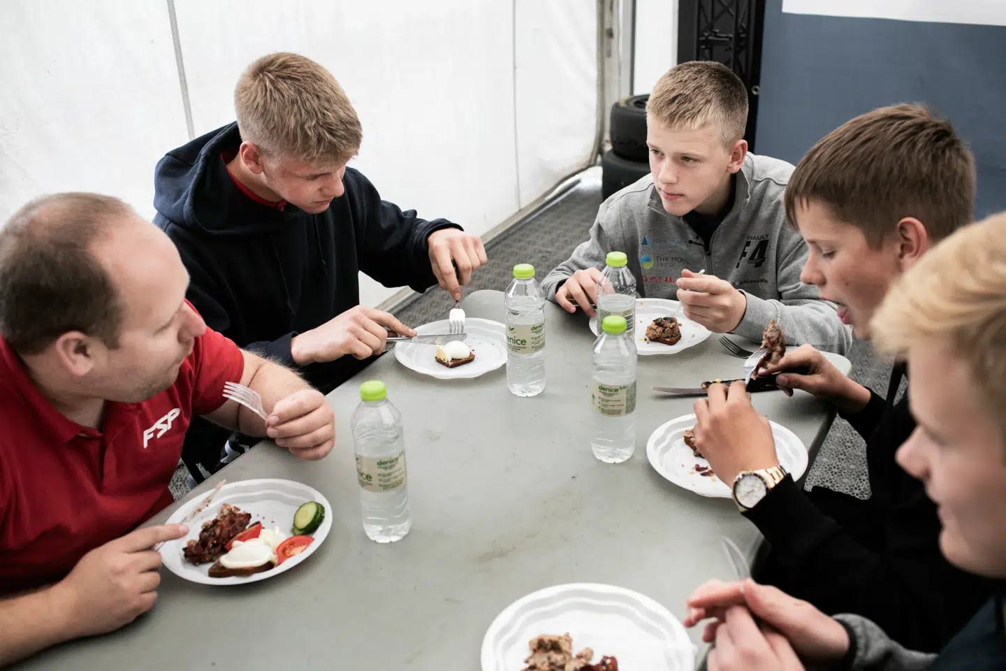 Teamet spiser frokost og diskuterer weekendens stævne. Racerløb er ikke en enmandssport – ud over køreren er der mekaniker, træner og assistenter.
