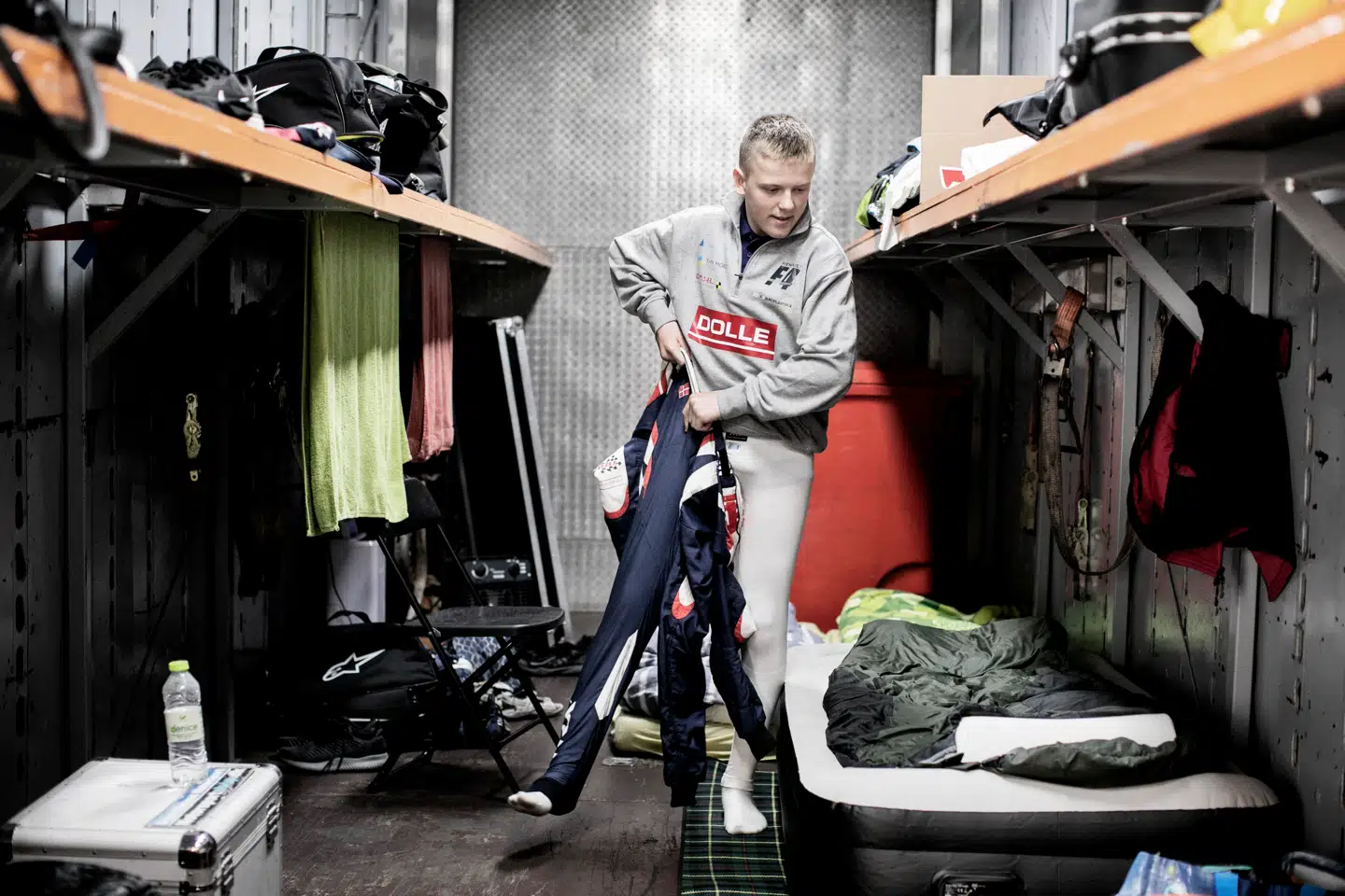 Malthe trækker i den brandhæmmende køredragt i lastvognstraileren. Han og familien sover i traileren denne weekend. Det er også her, bilerne holder, når de kører til stævne.