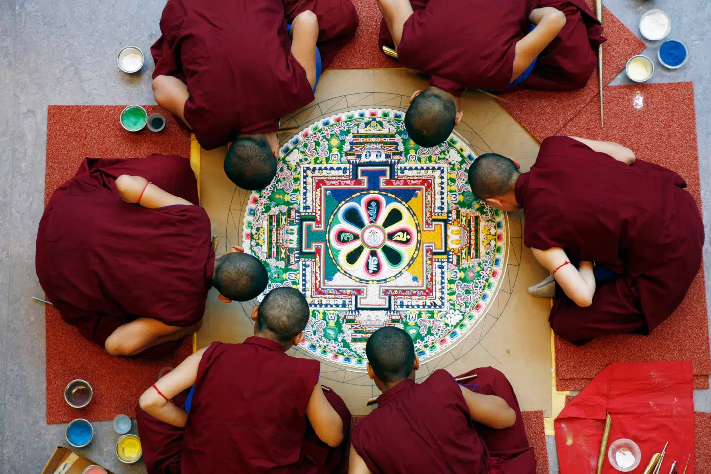 Milde munke vil lægge en mandala på Moesgaard: Et buddhistisk mikrokosmos drysset som et cirkulært mønster i flerfarvet sand. Her en tilsvarende seance i Haag. Foto: Museon The Hague