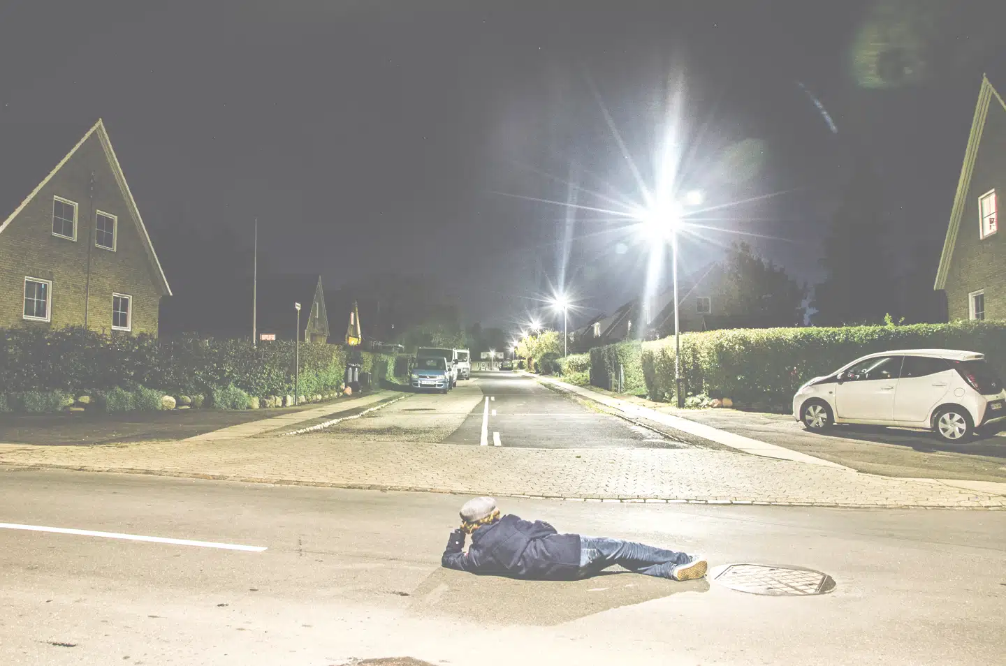 Hvad gør man, når der ikke er noget interessant at fotografere? Carl lagde sig midt på vejen i et stille villakvarter og brugte kameraets selvudløser.