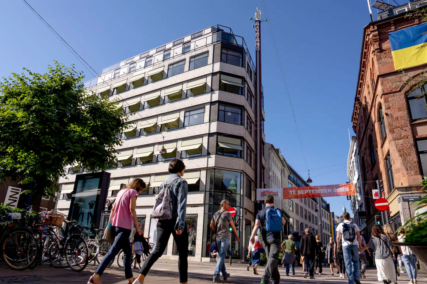 Højt oppe i den blå sommerhimmel klatrer en nøgen kvinde rundt på jagt efter et pelsdyr. Både skulpturen og huset, den reklamerer for, er for nylig blevet sat i stand.