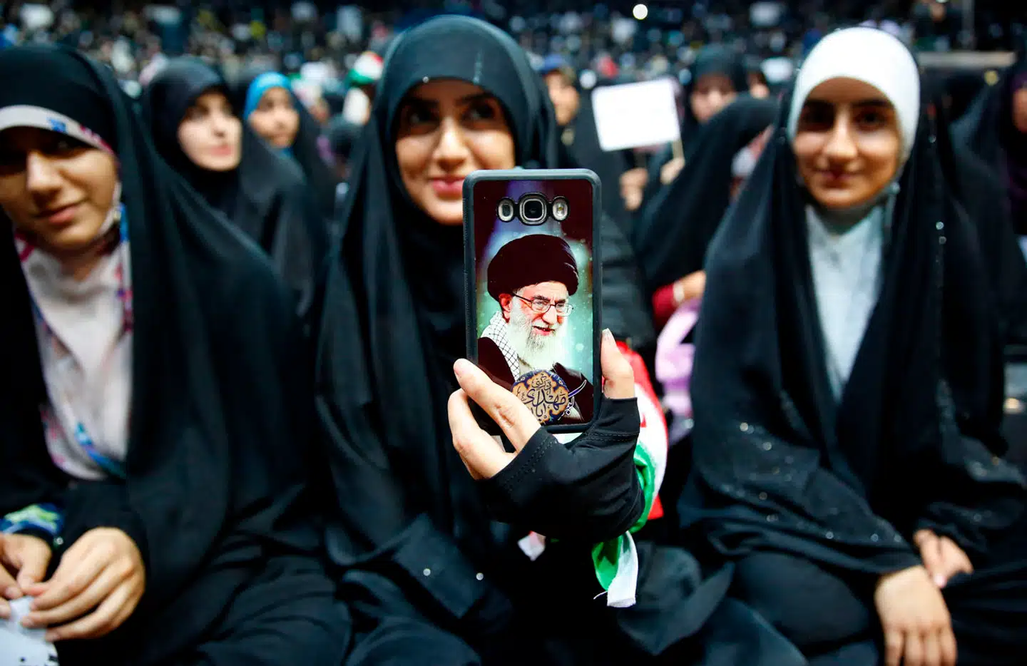 En iransk kvinde holder sin telefon frem med et billede af landets øverste gejstlige leder Ayatollah Ali Khamenei i en protest, der støtter kravet om at bære tørklæde.