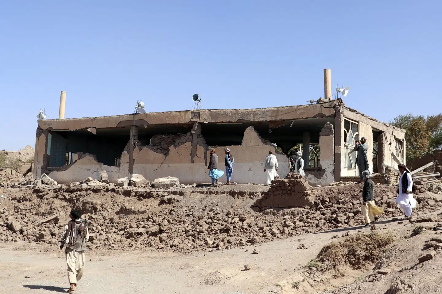Afghanske mænd rydder op i murbrokkerne ved en moské i den vestlige provins Herat i Afghanistan, efter et kraftigt jordskælv lørdag ødelagde den.