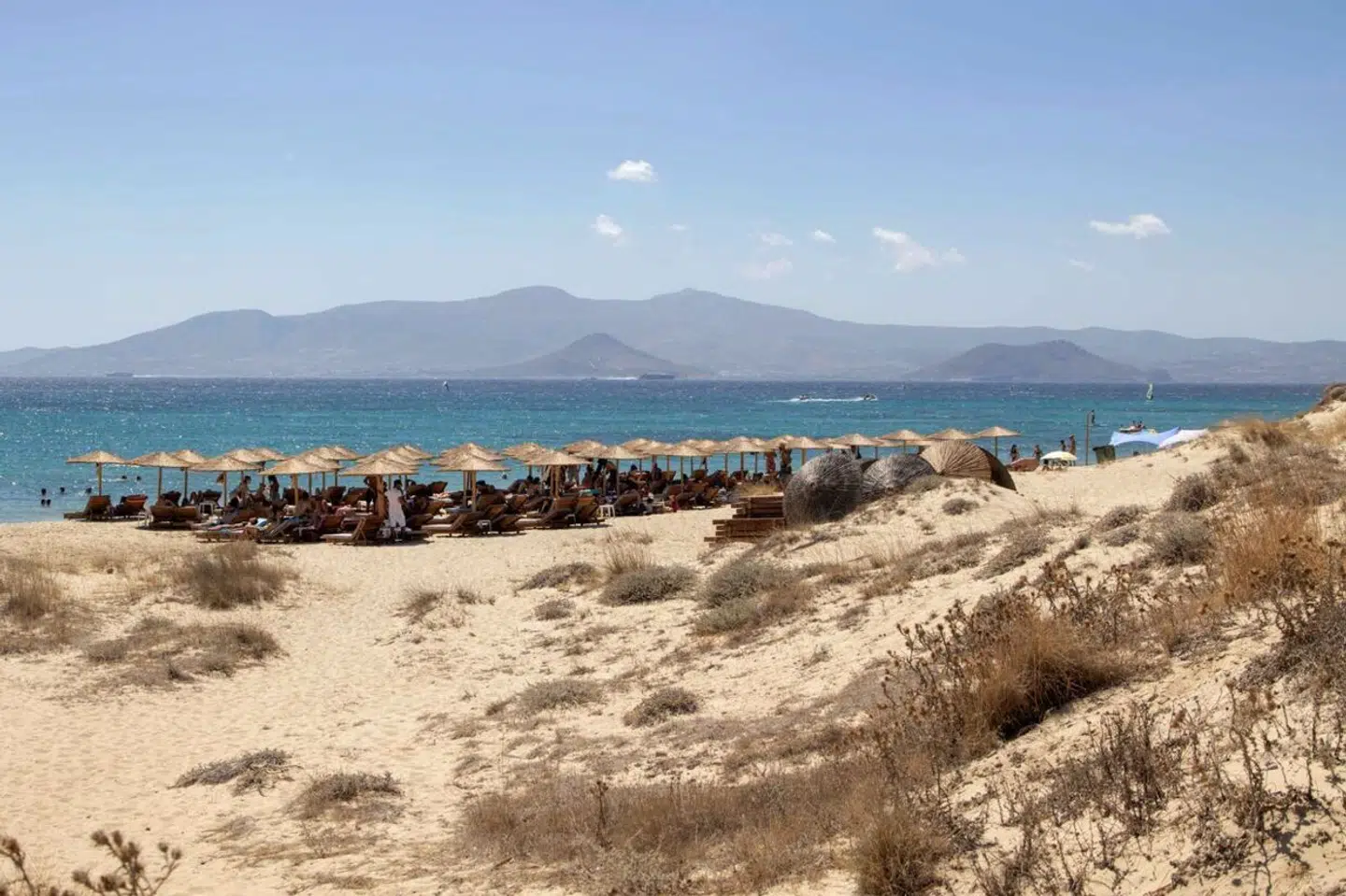 Turister, der nyder solen på den græske ø Naxos, som skulle være en del billigere end Mykonos. REUTERS/Stringer Foto: Stringer/Reuters/Ritzau Scanpix
