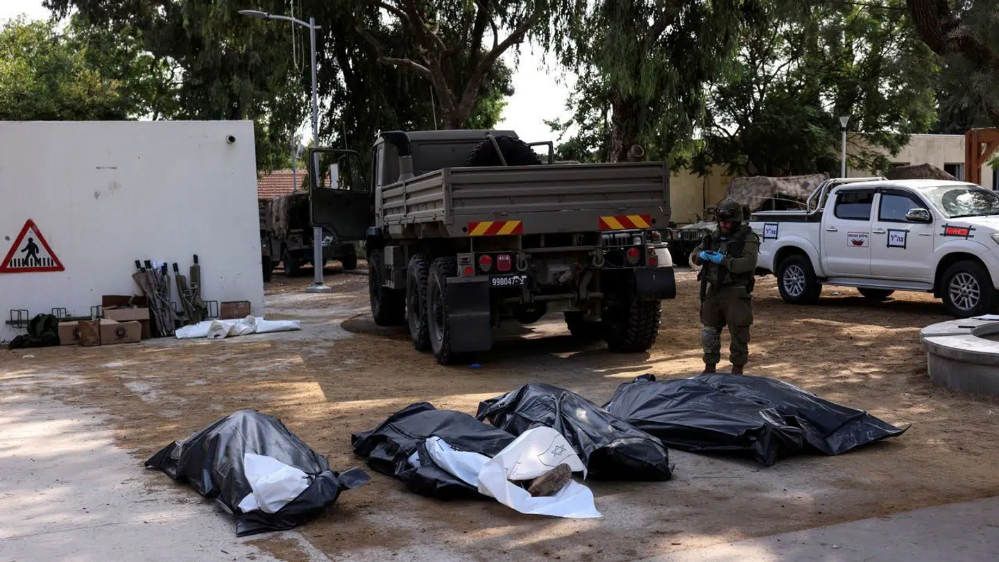 Bodies of victims of an attack, following a mass infiltration by Hamas gunmen from the Gaza Strip, lie on the ground in Kibbutz Kfar Aza, in southern Israel, October 10, 2023. REUTERS/Ronen Zvulun