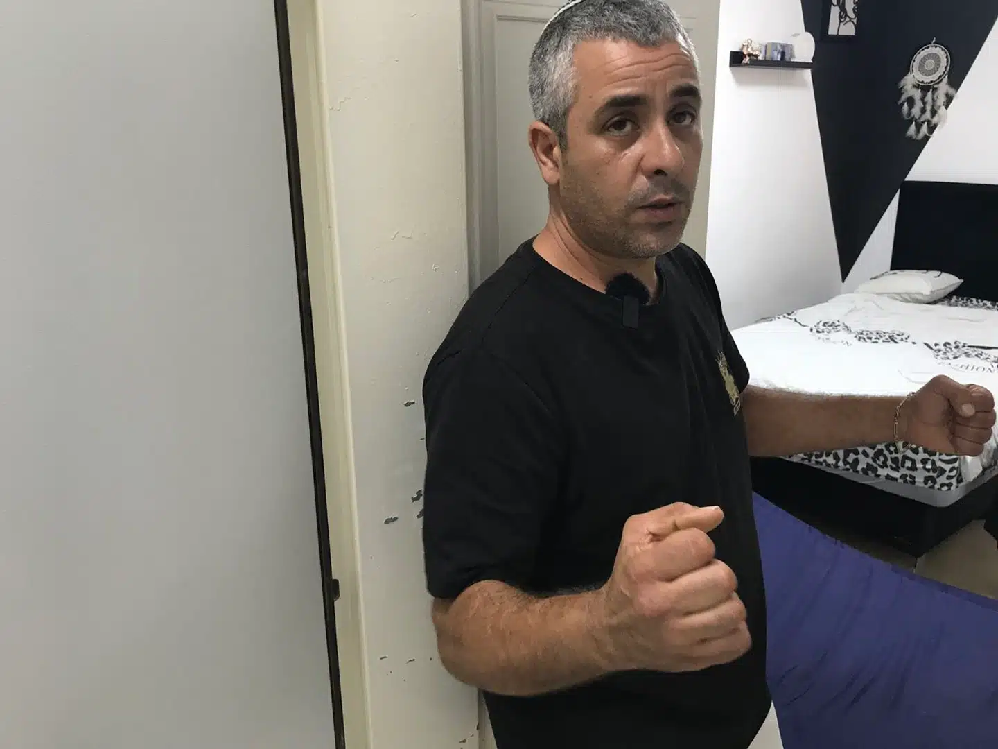 Yoni Shlomo viser, hvordan han hele tiden holdt en kniv parat til at forsvare sig mod mulige indtrængende terrorister, mens han fik familien ind i sikkerhedsrummet, som plejer at yde beskyttelse mod truslen fra raketter.