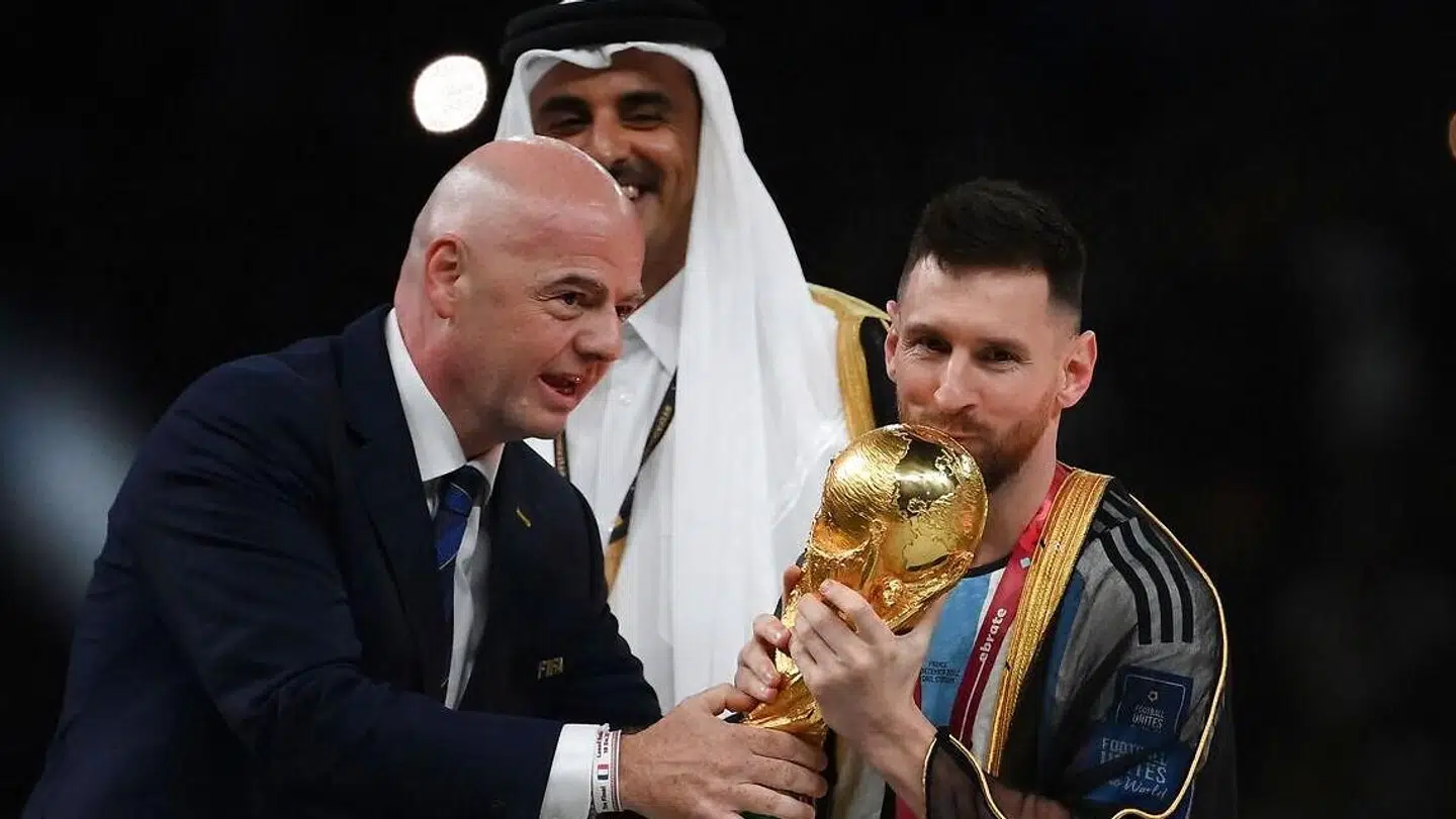 Lionel Messi modtager VM-trofæet af FIFA-præsident Gianni Infantino, efter Qatars emir Sheikh Tamim bin Hamad al-Thani har iklædt argentineren den sorte bisht.