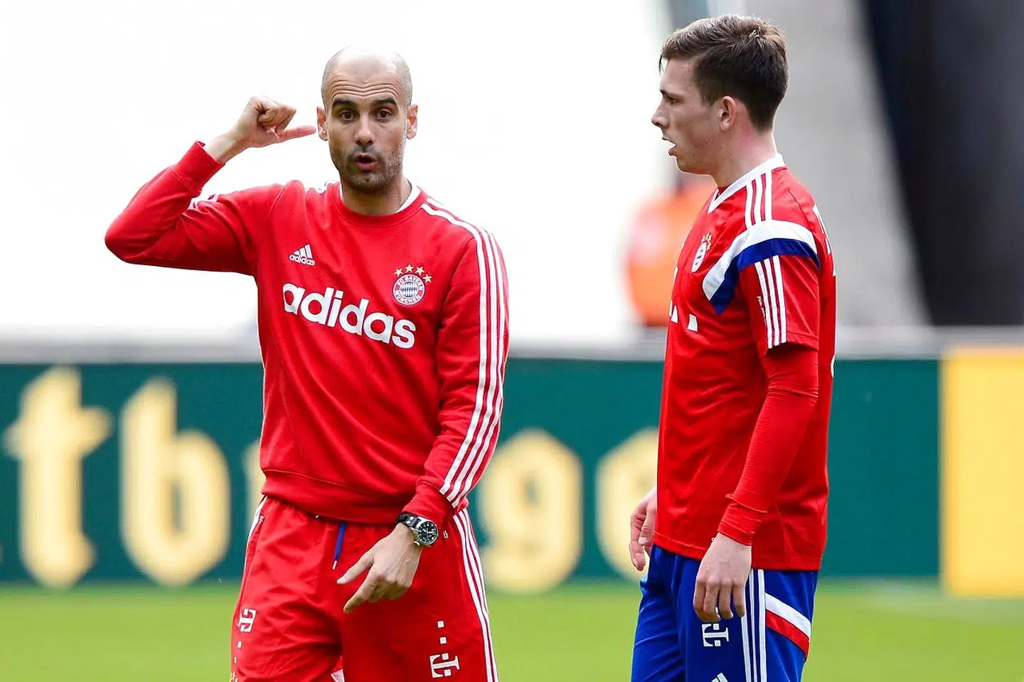 Bayern Munich's Spanish head coach Pep Guardiola (L) speaks with Bayern Munich's Danish midfielder Pierre Hojbjerg during a training session in Berlin on May 16, 2014 on the eve of the DFB German Cup final football match BVB Borussia Dortmund vs Bayern Munich. AFP PHOTO / JOHN MACDOUGALL