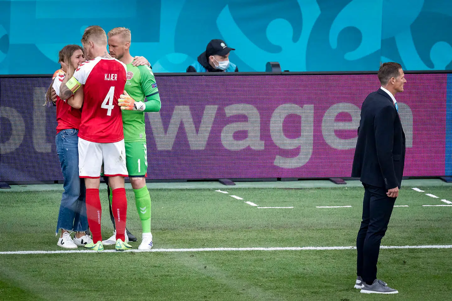 Simon Kjær og Kasper Scmeichel trøster Christian Eriksens kæreste, Sabrina, på grønsværen.