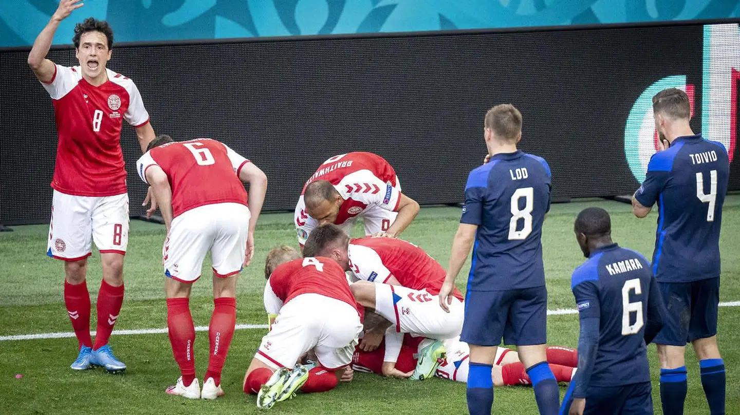 Thomas Delaney (tv.) råber efter hjælp, mens holdkammeraterne forsøger at hjælpe Christian Eriksen.