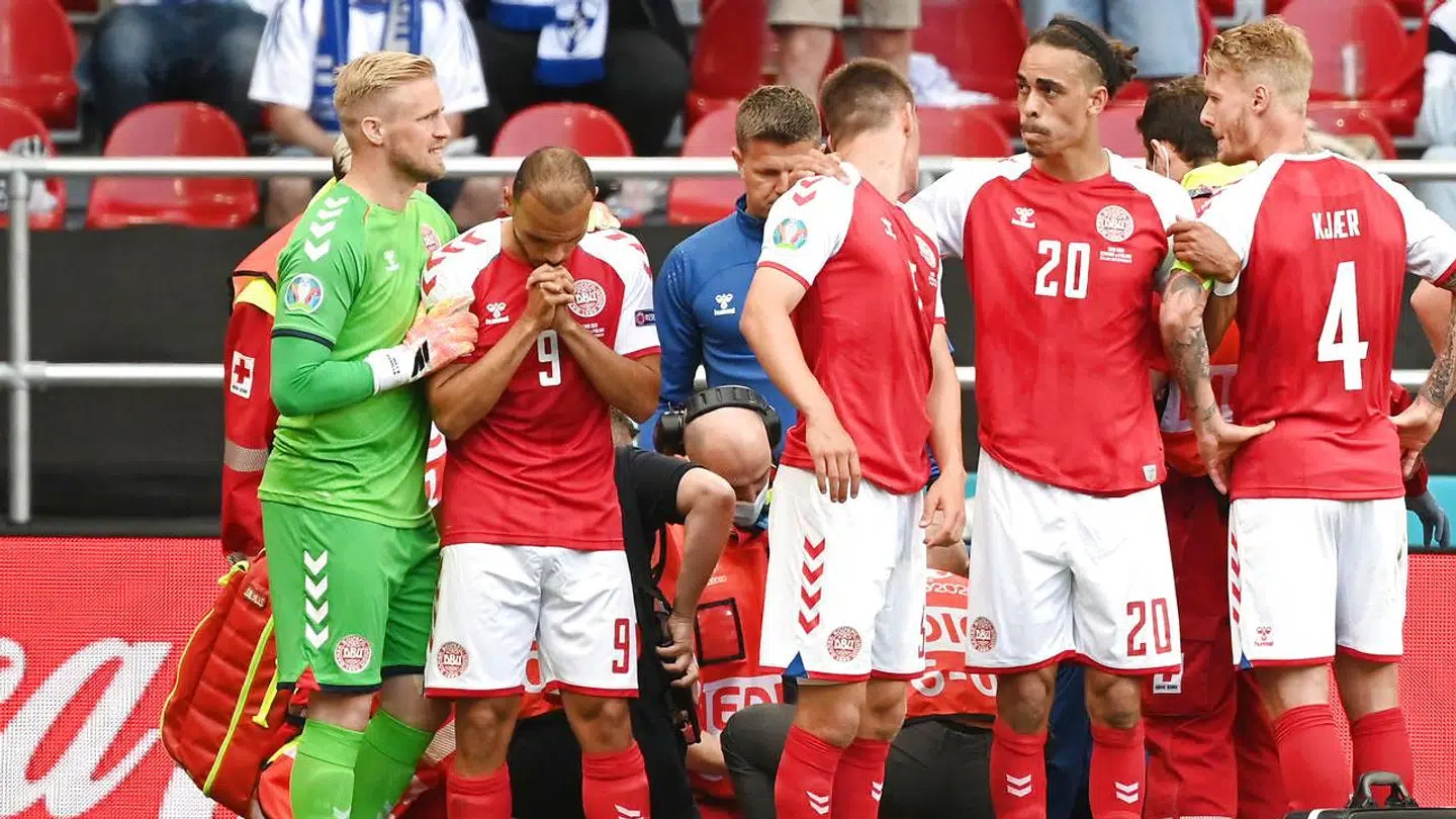 De danske landsholdsspillere danner en menneskering om Christian Eriksen, der modtager behandling.