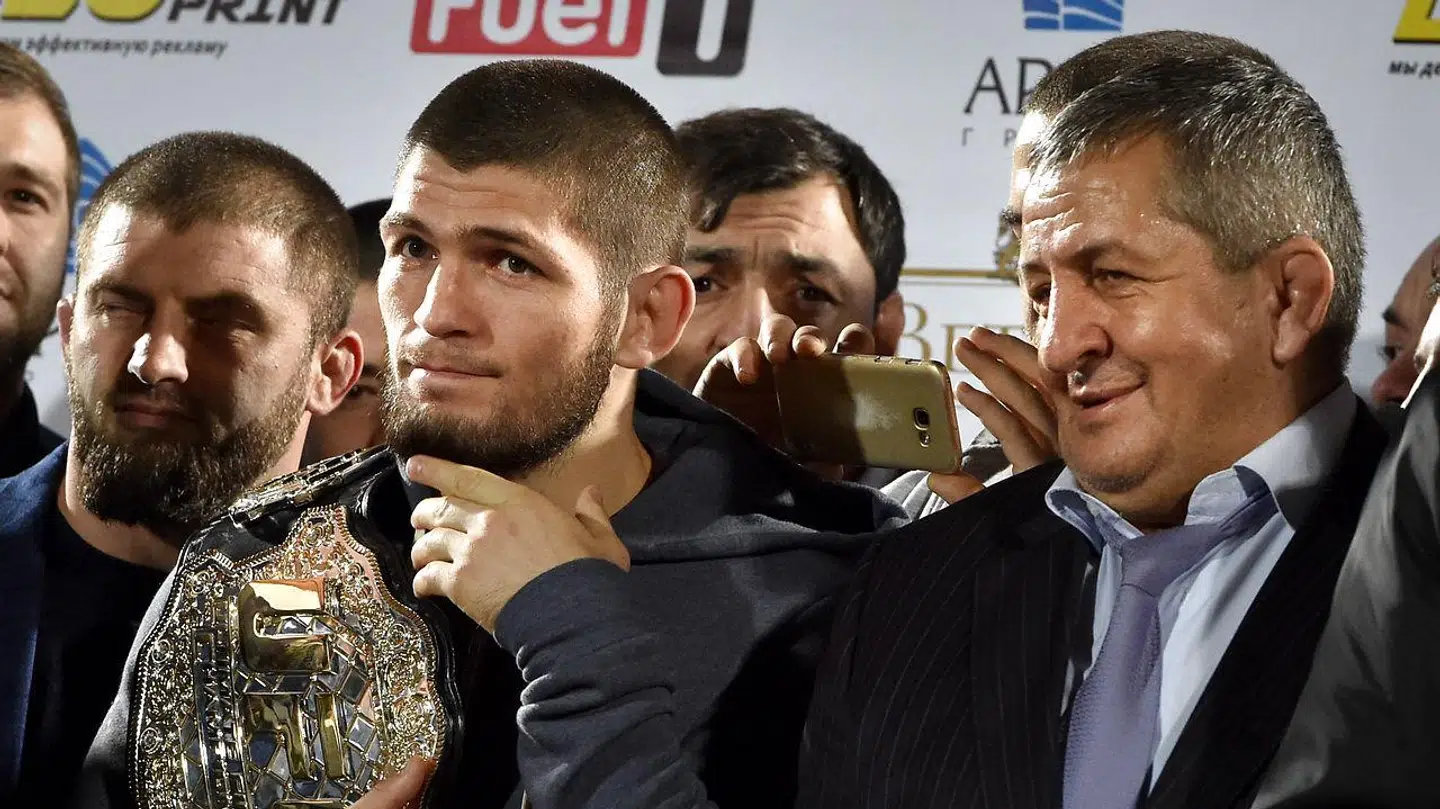 Khabib Nurmagomedov holder sit titelbælte, mens Abdulmanap Nurmagomedov stolt kigger på.