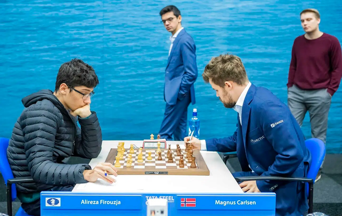 Magnus Carlsen under nederlaget til det iranske supertalent Alireza Firouzja (tv.). I baggrunden går Anish Giri, som skulle slå verdensmesteren knap 10 dage senere.