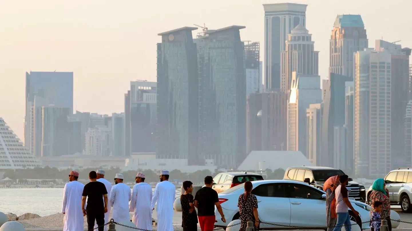 People look at the Doha skyline from the old city port on September 22, 2023. (Photo by KARIM JAAFAR / AFP)