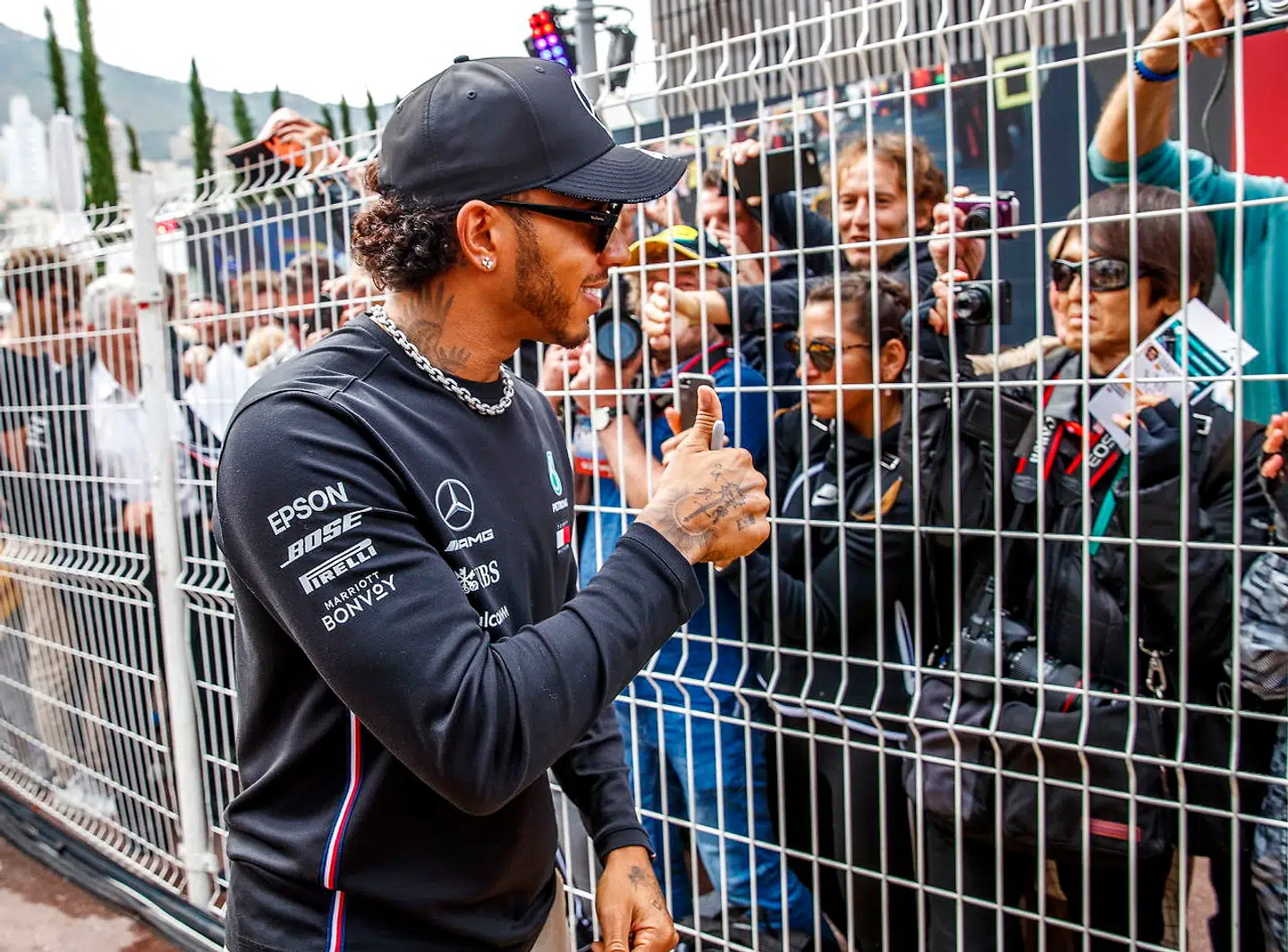 Lewis Hamilton skriver autofgrafer.