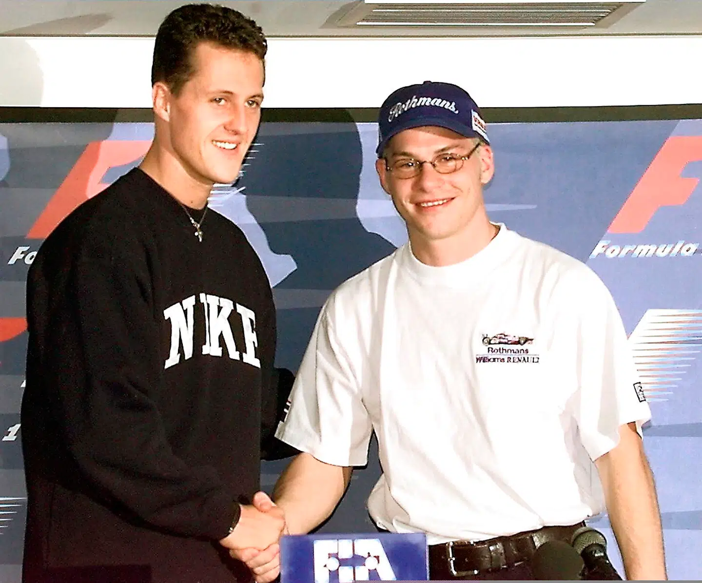 German Ferrari driver Michael Schumacher (L) and Canadian Williams-Renault driver Jacques Villeneuve shake hands 23 October during a press conference on the Jerez racetrack, where they will participate the season-ending European formula one Grand Prix, 26 October. Schumacher leads concurrent Villeneuve by one point in the world championship. (ELECTRONIC IMAGE) PIERRE VERDY / AFP