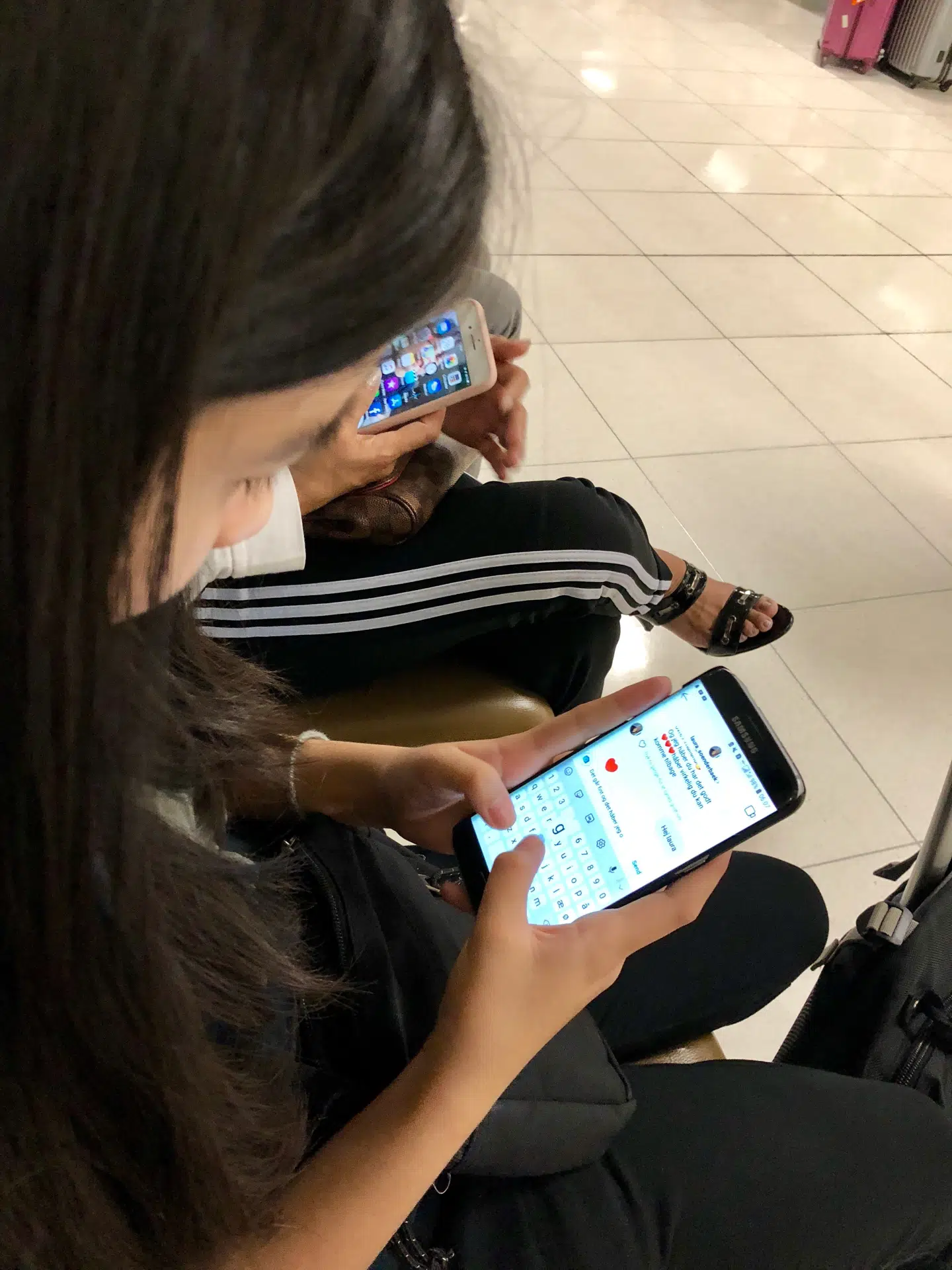 Mint fordriver ventetiden i lufthavnen med snapchat, instagram- og messengerbeskeder med vennerne hjemme i Danmark.