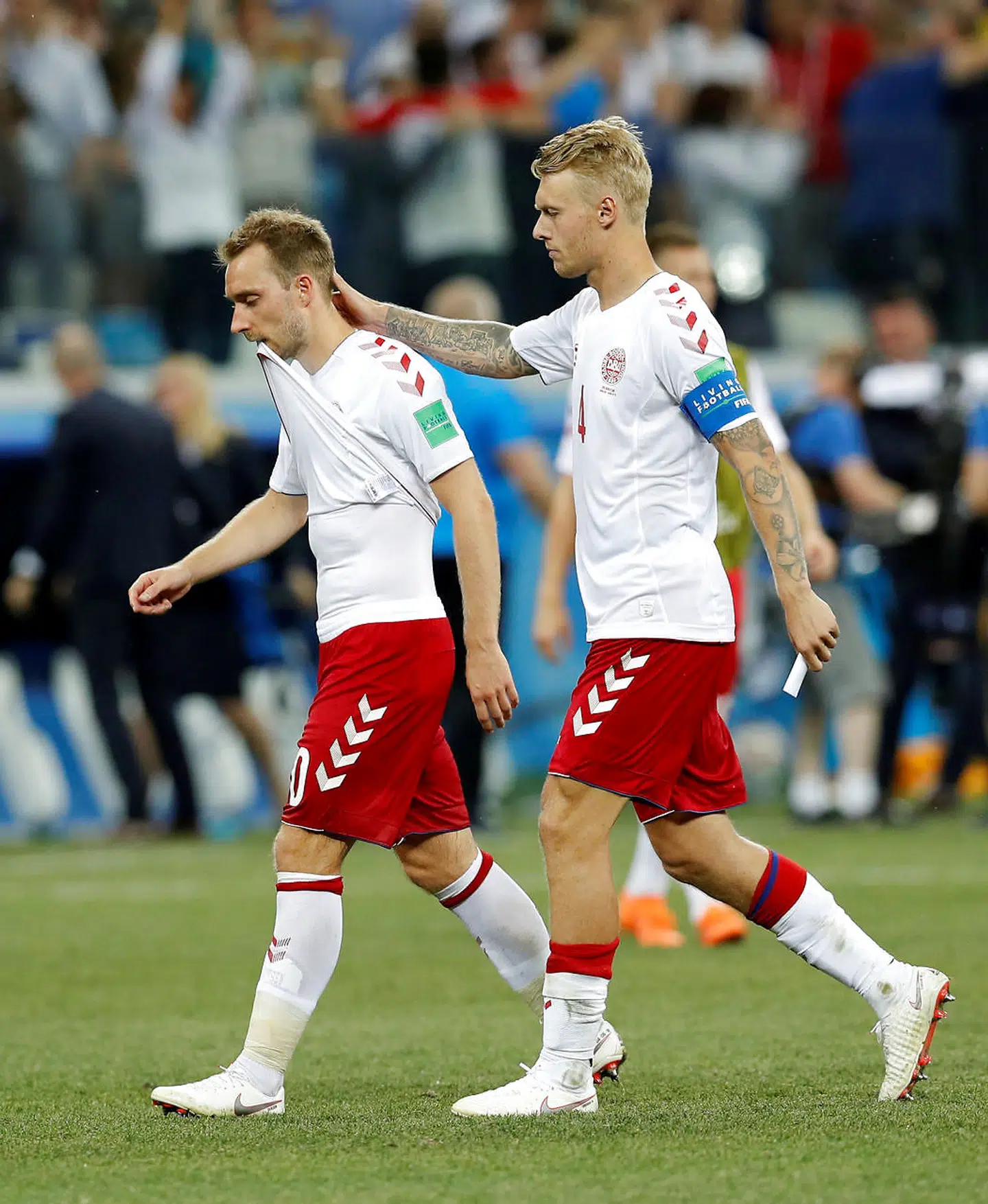 Christian Eriksen får en trøstende hånd i nakken af Simon Kjær.