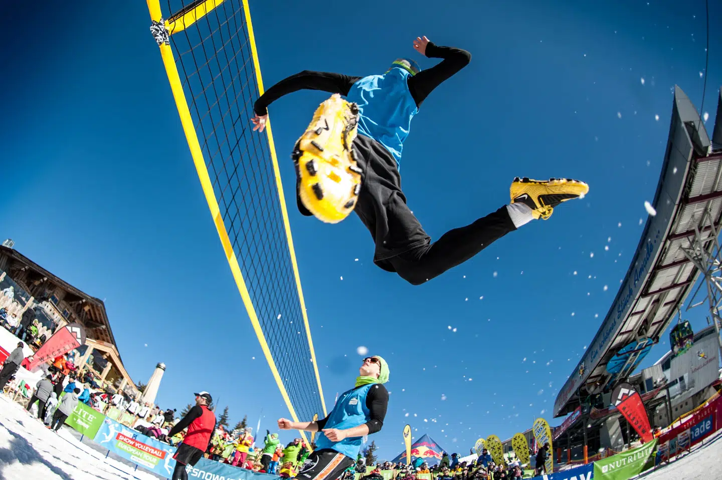 Fodboldstøvler sikrer, spillerne står fast i sneen og kan sætte ordentligt af til at smashe. Der er garanti for god underholdning for alle både på og uden for banerne under mesterskabet den 23.-25. marts. Foto: Snow Volleyball CEV Tour