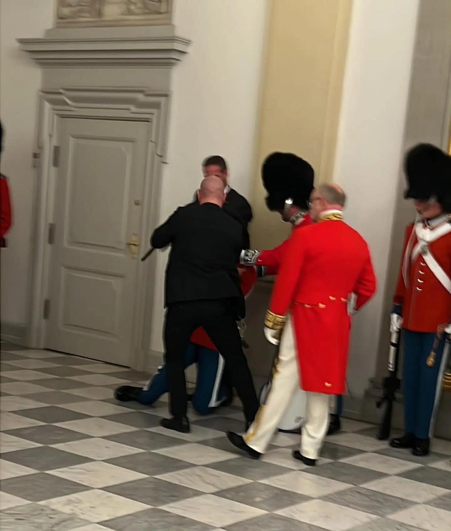 En garder besvimer under ankomsterne til gallamiddagen. Foto: Anthon Unger.