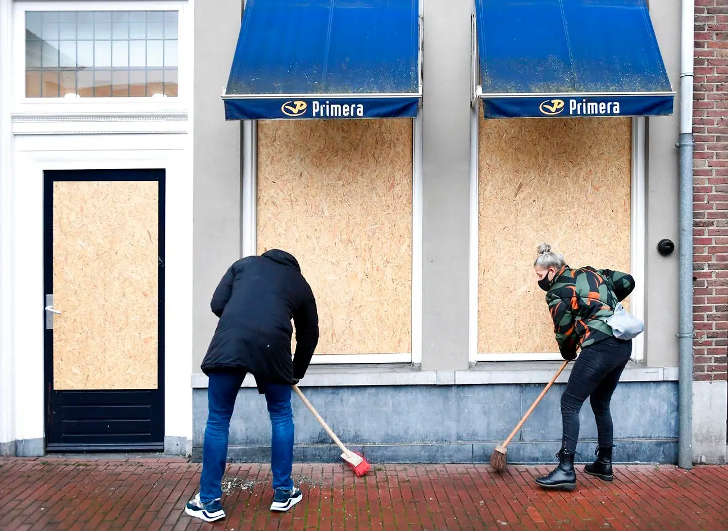 Tirsdag rydder borgere op i gaderne i den hollandske by Den Bosch. Mandag hærgede voldelige demonstranter for tredje nat i træk facader, butikker og andet i byen.