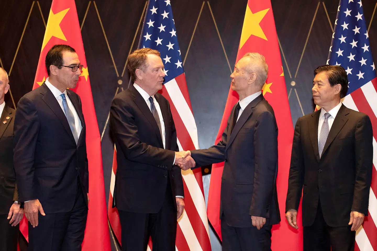 USAs handelsudsending, Robert Lighthizer, trykker hænder med Kinas vicepremierminister, Liu He, mens USAs finansminister Steven Mnuchin og Kinas handelsminister Zhong Shan ser på i Xijiao Conference Center i Shanghai 31. juli 2019. Forhandlingerne endte dog uden resultat.