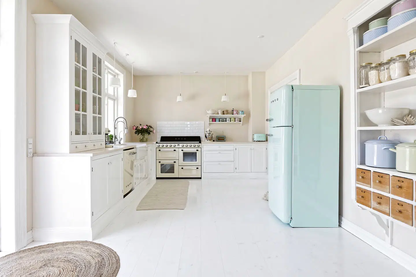 Det oprindelige køkken og bryggerset er slået sammen, og køkkenet er udskiftet med et nyt fra svenske Kvänum. Det flødefarvede komfur er lige som det mintgrønne køleskab fra italienske Smeg. En flødefarvet opvaskemaskine og en babyblå vaskemaskine er fra samme producent.