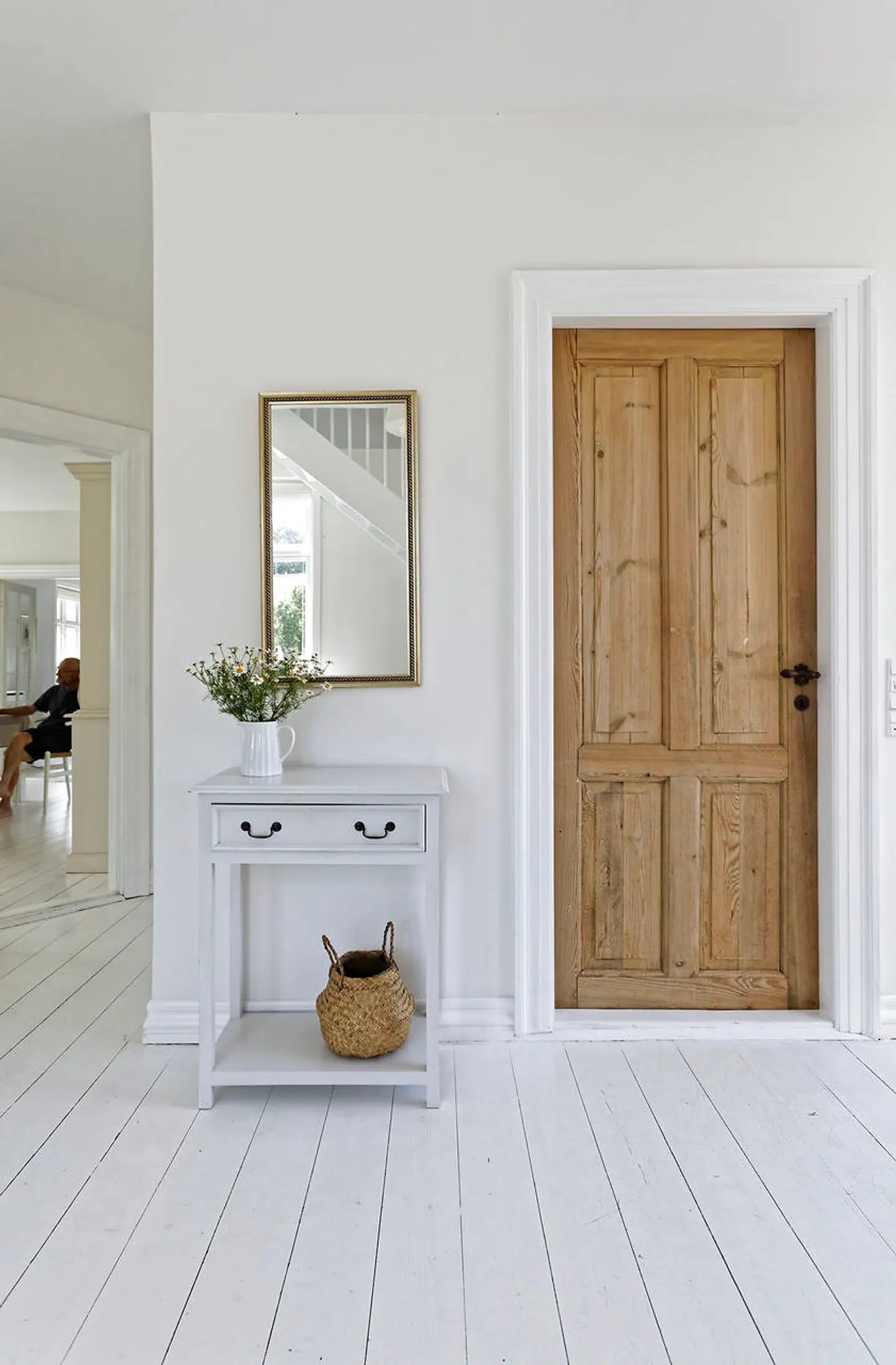 De hvidmalede gulve står i kontrast til den rå dør.