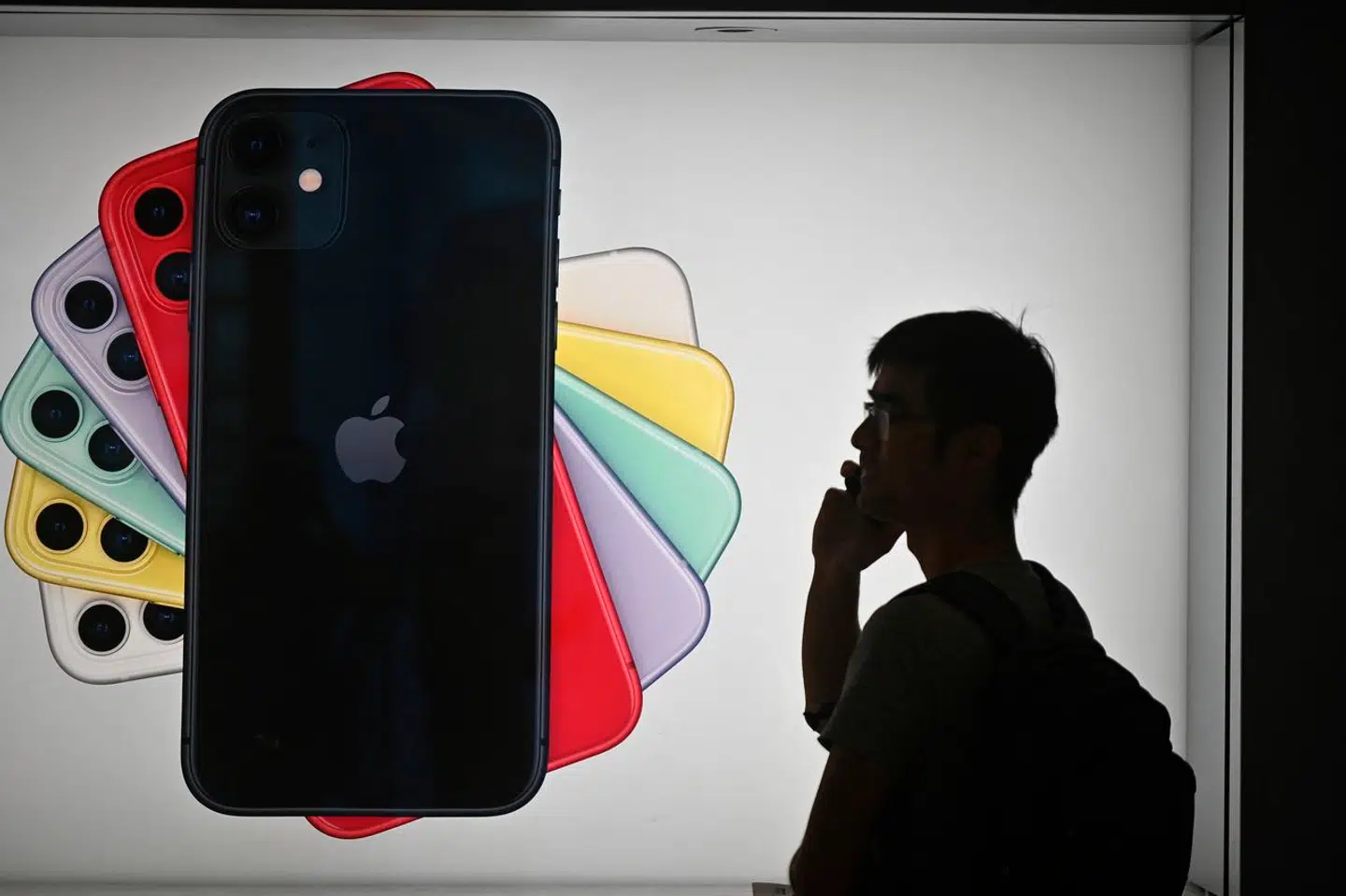 En mand passerer forbi en iPhone-reklame, mens han taler i telefon. Vi må håbe, at han ikke lægger en telefonbesked eller foretager et spontant telefonopkald. For så bryder han etiketten.