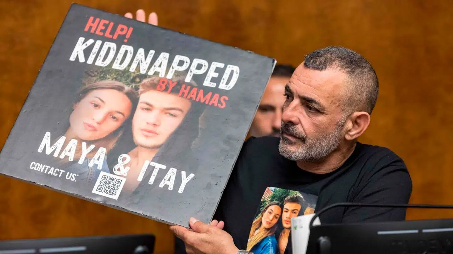 Ilan Regev Gerby viser en plakat, som viser hans to børn, Maya og Itay, der begge blev taget som gidsler af Hamas under terrorangrebet 7. oktober. Nu er Maya Regev frigivet, men lillebroren Itay holdes stadig som gidsel af terrororganisationen.