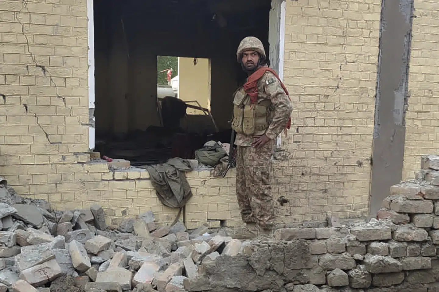En soldat fra hæren ser nærmere på skaderne efter et angreb mod en midlertidig pakistansk militærbase.