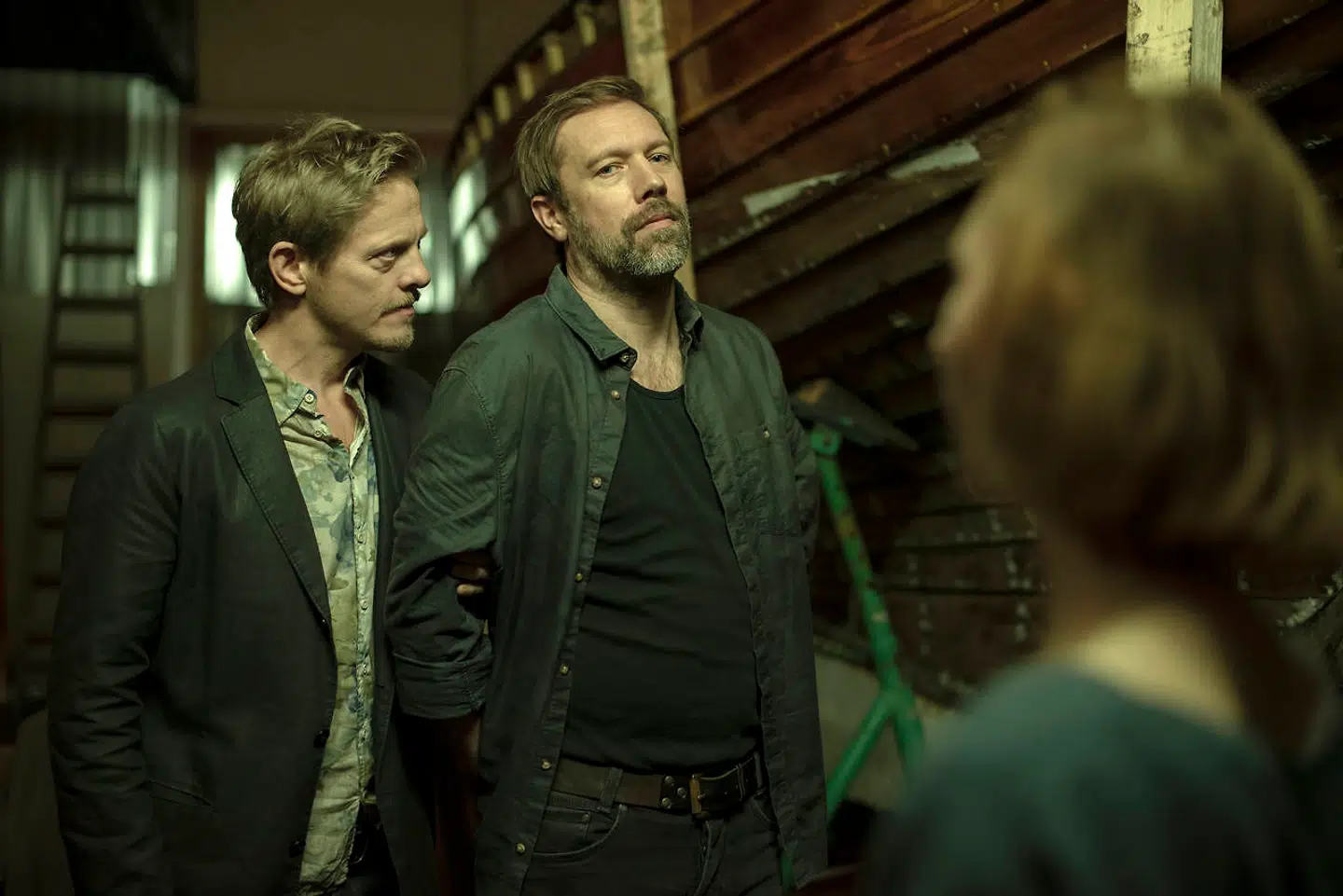 Jacob Cedergren (i midten) er en mystisk onkel, der kommer til byen og truer med at afsløre hemmeligheder fra fortiden i DRs »Under Overfladen«, der - især mod slutningen - Især mod slutningen er så behængt med drab, hemmelige affærer, trafikulykker, livstruende sygdomme, narko, alkoholisme, at selv manuskriptforfatterne til sæbeoperaen »Glamour« måske ville sige: »Okay, slap lige af.«Foto: DR