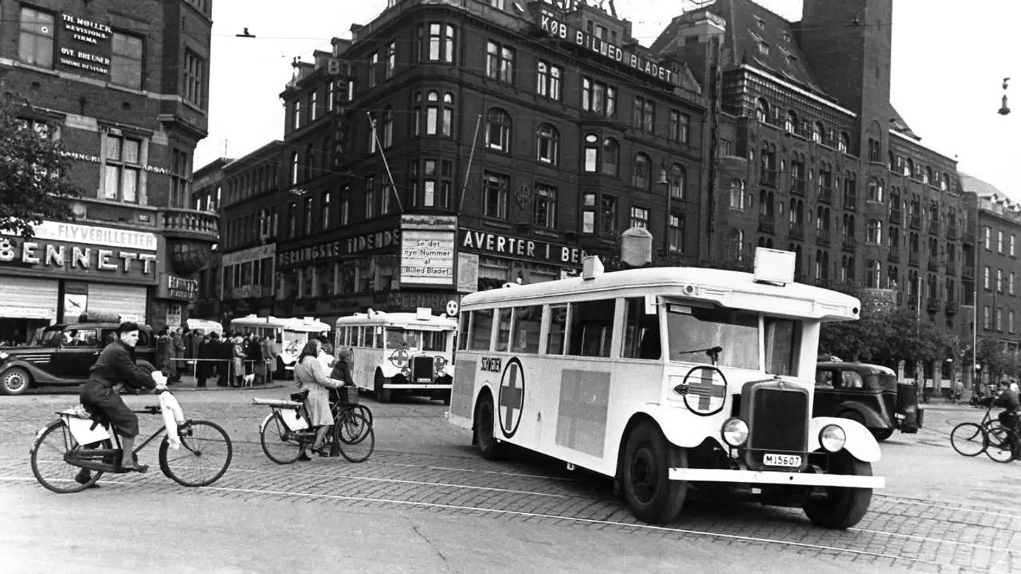 Hvide Røde Kors-busser bragte kz-fanger hjem til Danmark efter befrielsen. Her er det busser, der kører forbi Rådhuspladsen. Klaus Larsen Larsen beskriver også den indsats i sin bog, men kun ud fra den danske litteratur.