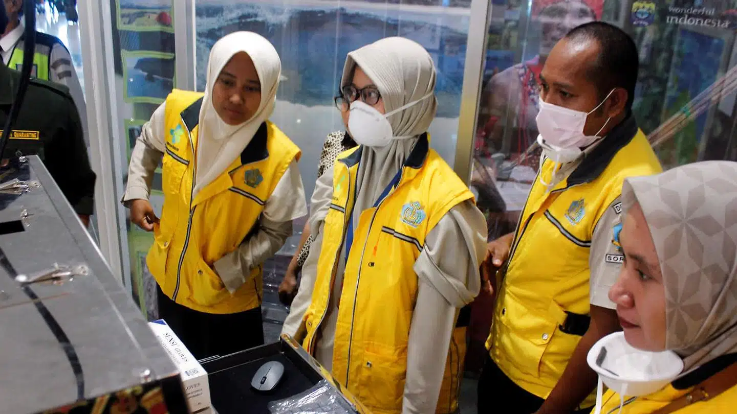 Personale overvåger en varmescanner i Dominique Edward Osok-lufthavnen i Sorong i Indonesien.