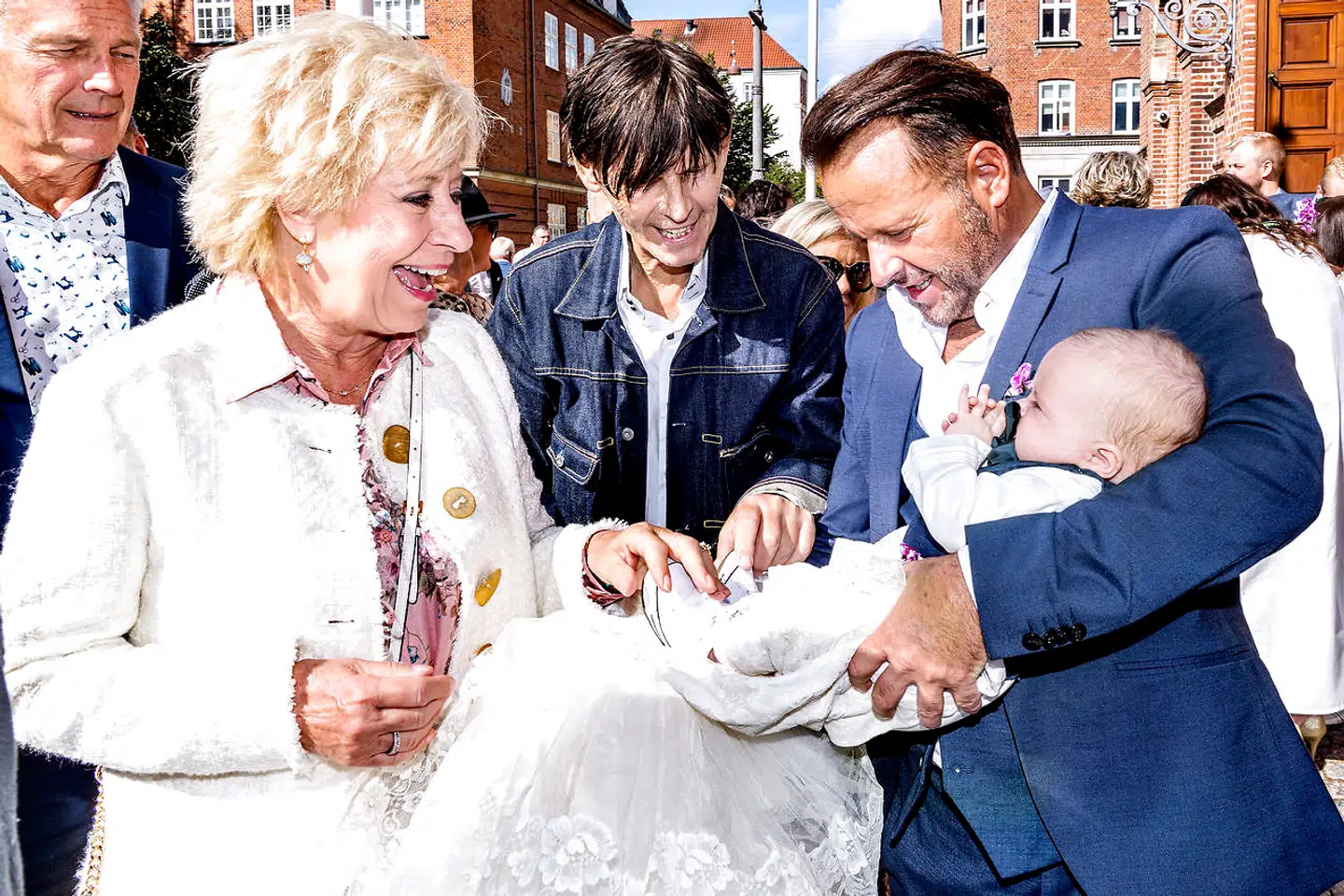 Birthe Kjær hilser på Lucas og Dennis Knudsen efter dåben.