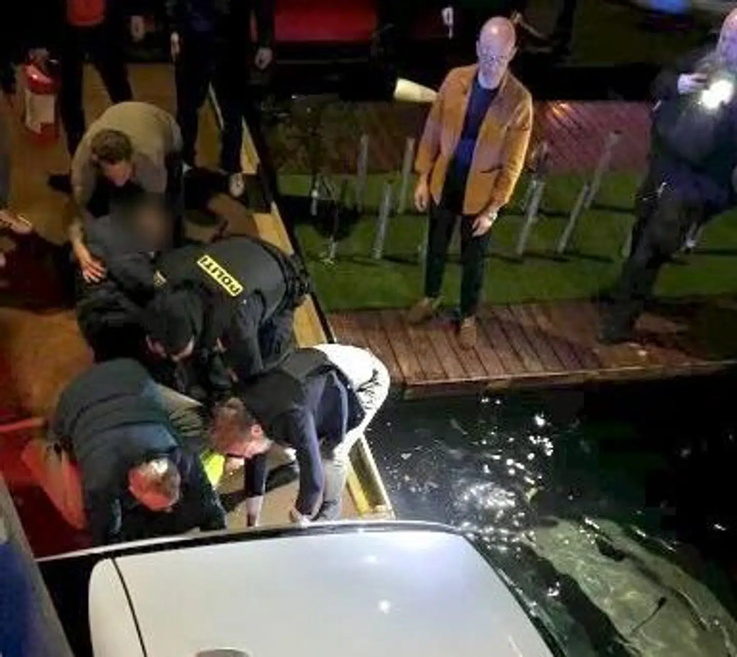 Et vidne tog dette foto af redningsaktionen, hvor øjenvidnerne fik reddet ægteparret ud af den synkende bil. Bagest står Sas Popovic med brandslukkeren i hånden.