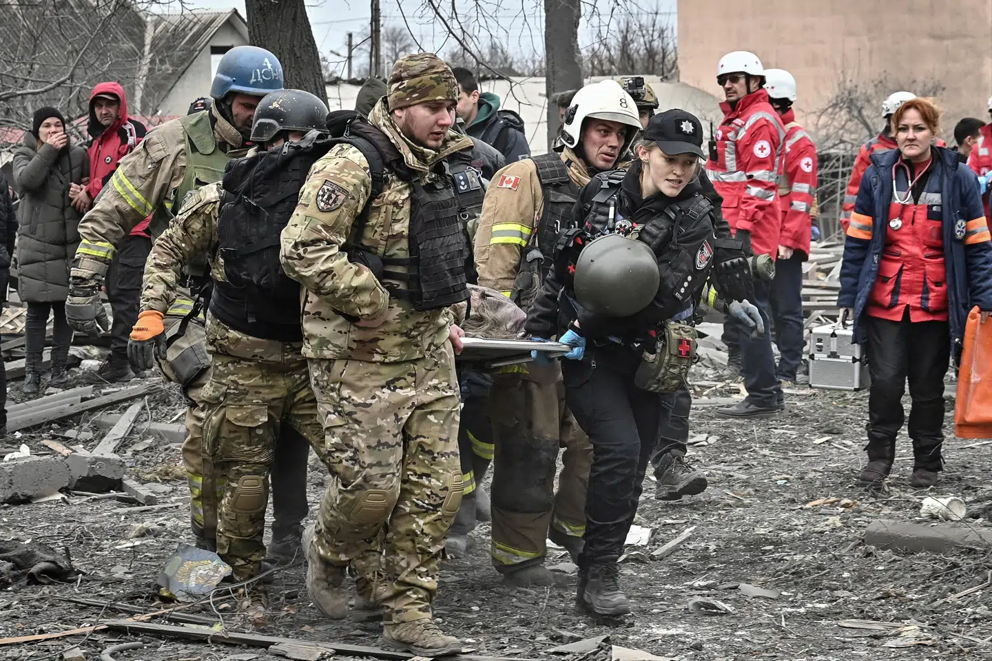 Ukrainske politifolk og soldater bærer en død person væk, efter en russisk raket fredag er slået ned i byen Zaporizjzja. En række ukrainske byer var fra tidlig nat mål for et stort antal russiske raketter og krydsermissiler.