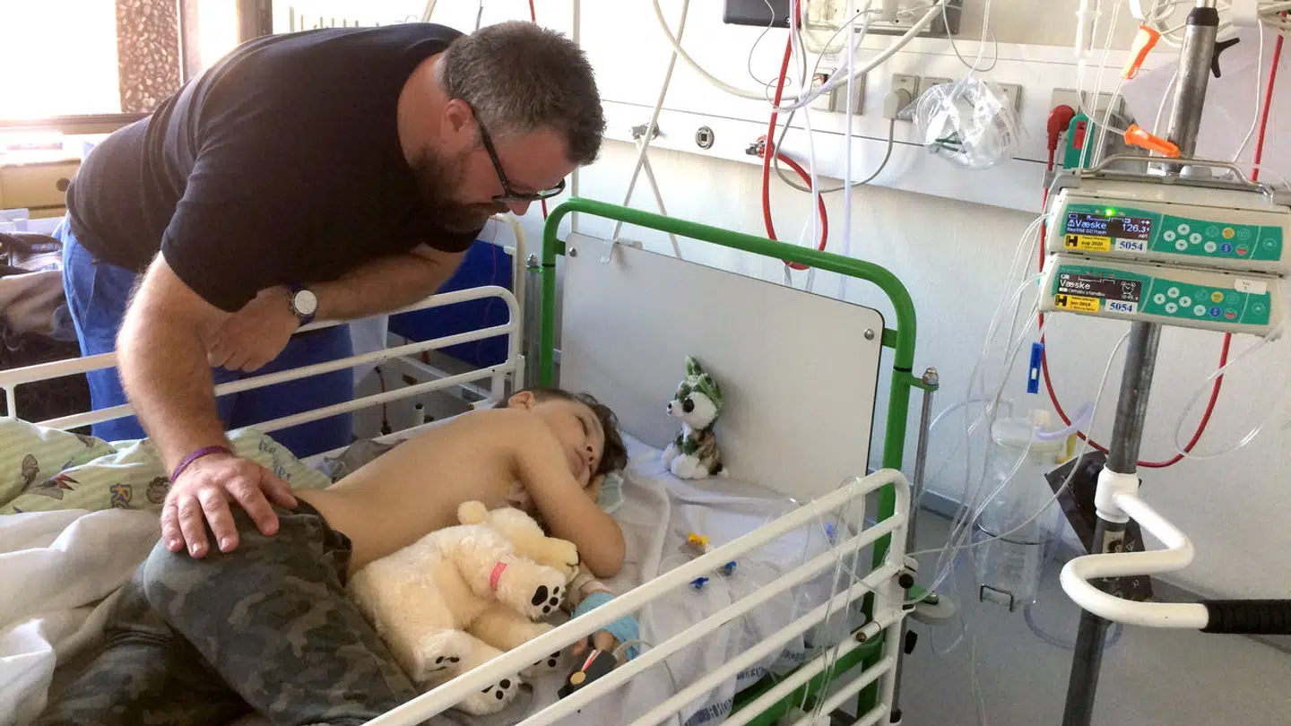 Jakob Kargaard, Julius' far, trøster Julius på børnekræftafdelingen. Julius ligger her med krammebamsen Theo, som indlagte børn med en svær sygdom får af hospitalet.