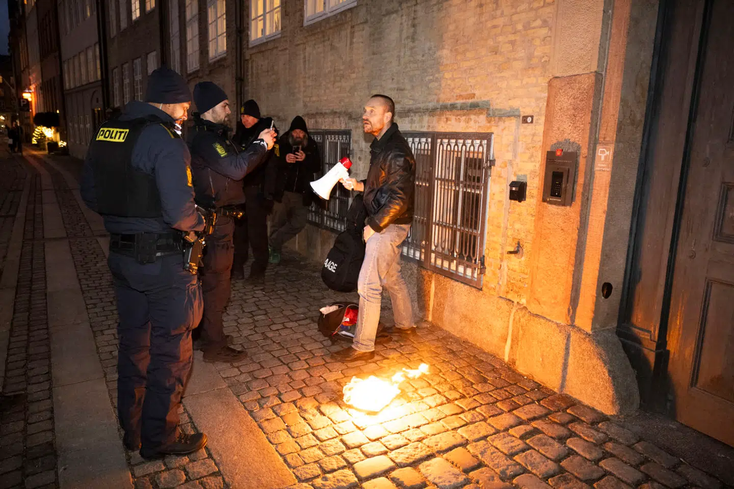 Lars Theilade konfronteres af politiet, mens han brænder en koran foran Kulturministeriet på dagen, hvor koranloven trådte i kraft.