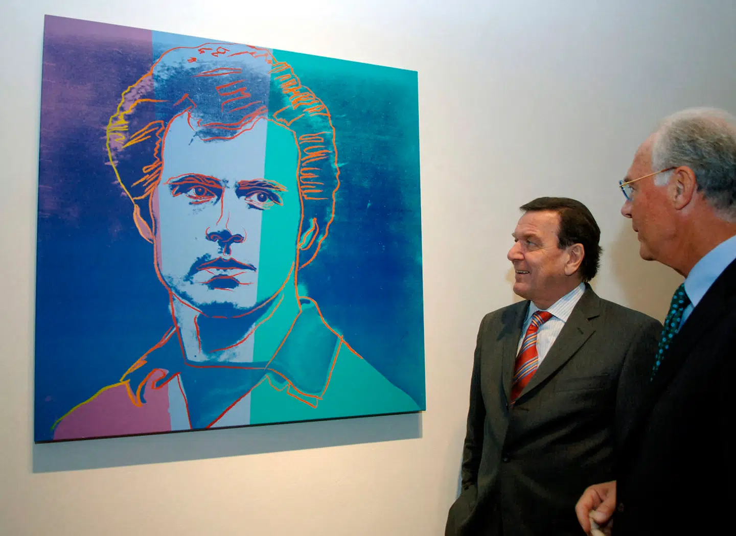 På et tidspunkt, hvor fodboldspillere fortsat overvejende spillede i hjemlige ligaer, tog Vesttysklands største stjerne til USA. Her spillede han for klubben New York Cosmos, og under opholdet lærte han kunstneren Andy Warhol at kende. Her ser Franz Beckenbauer og ekskansler Gerhard Schröder på et maleri, der kom ud af det møde.