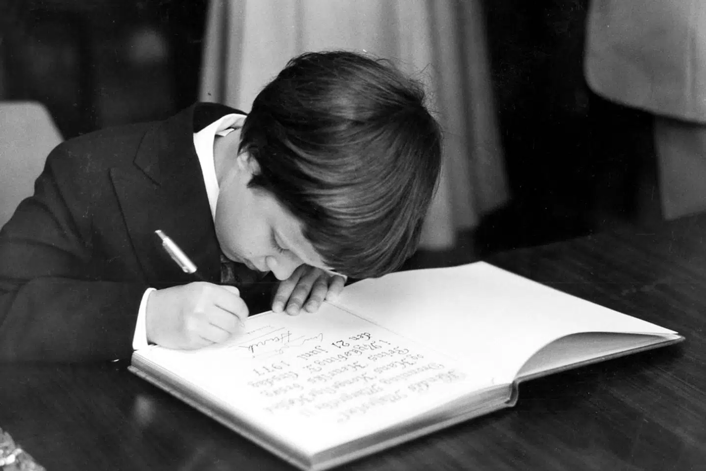 Kong Frederik som barn i 1977, med sin far og mor, Dronning Margrethe og prins Henrik, på besøg i Nykøbing Falster, hvor han skriver i kommunens gæstebog.